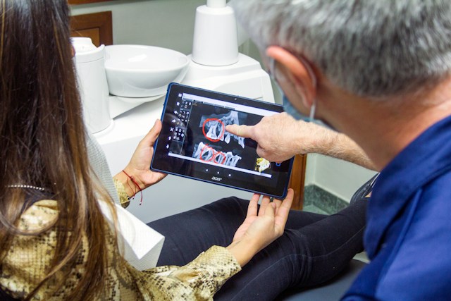 Dentist showing digital dental records on a tablet computer